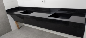 Lavaneta de Corian negra con múltiples lavabos para baño comercial de alto tráfico